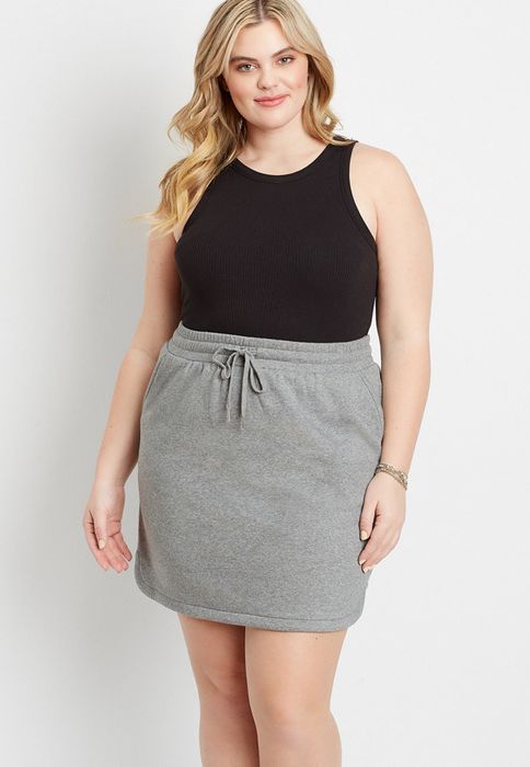 A model wearing a grey miniskirt with a drawstring waistband