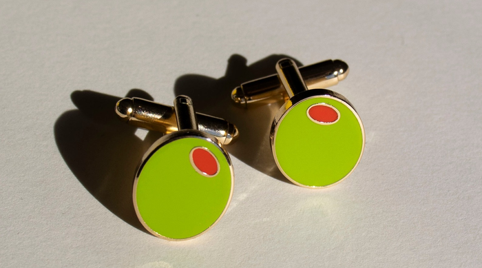 The green olive cufflinks featuring gold-tone metal accents.