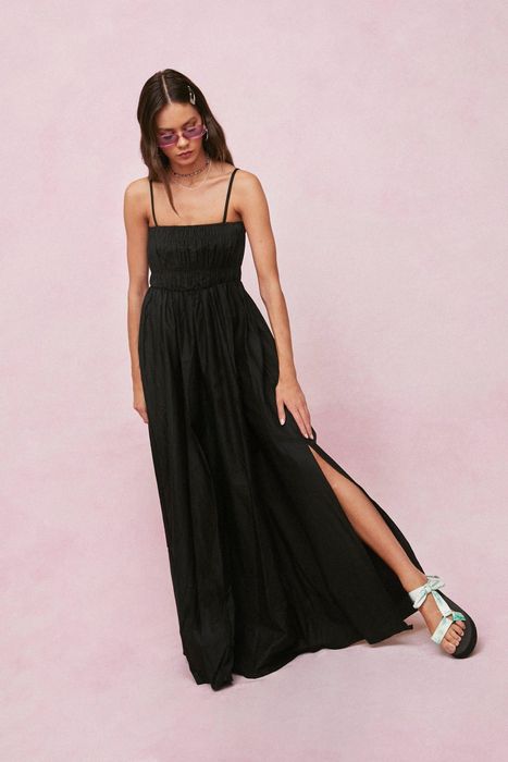 A model is seen wearing a black spaghetti strap dress.