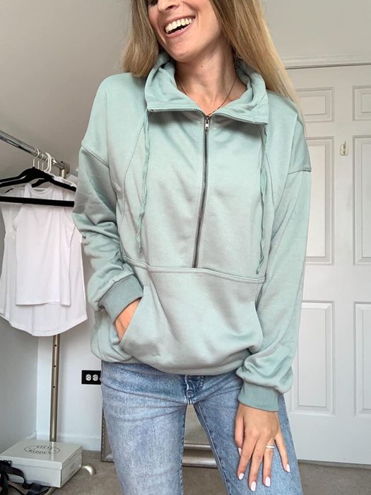 A model wearing a light blue quarter-zip sweatshirt