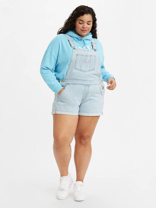 A model wearing the light wash short overalls