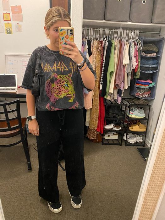 A reviewer wearing black palazzo pants