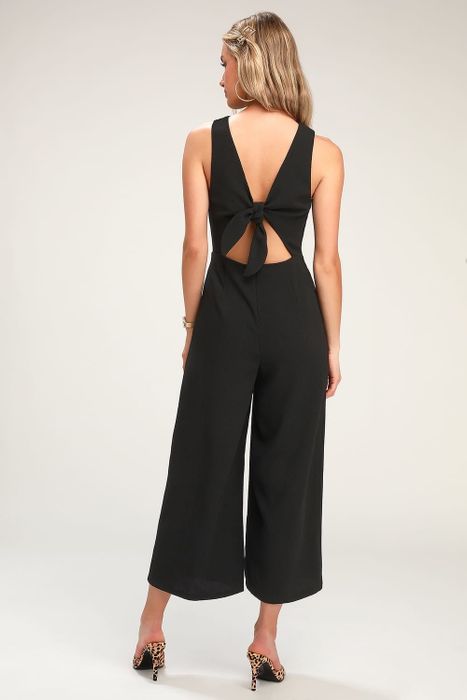 A model showcasing the black jumpsuit, viewed from the back