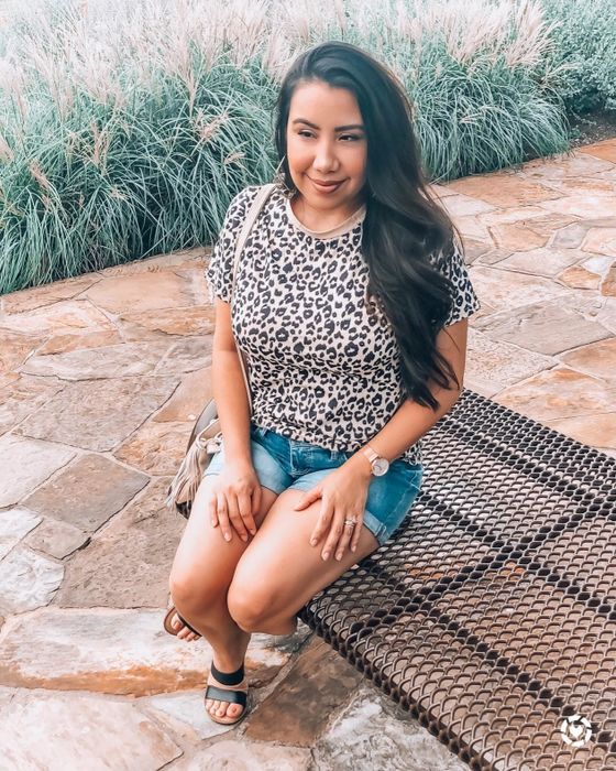 A reviewer wearing the leopard print tee paired with denim shorts
