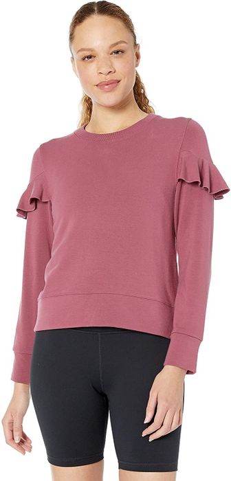 A model showcasing the dusty pink fleece sweatshirt