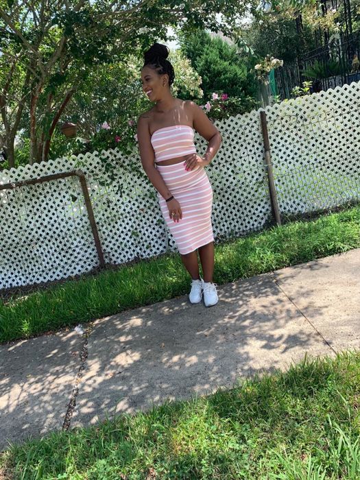 A reviewer showcasing the pink striped set, paired with sneakers