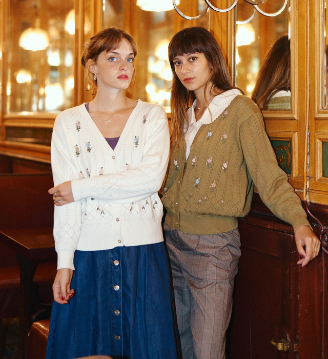 Two models are seen wearing the flower-embroidered cardigan in white and green.
