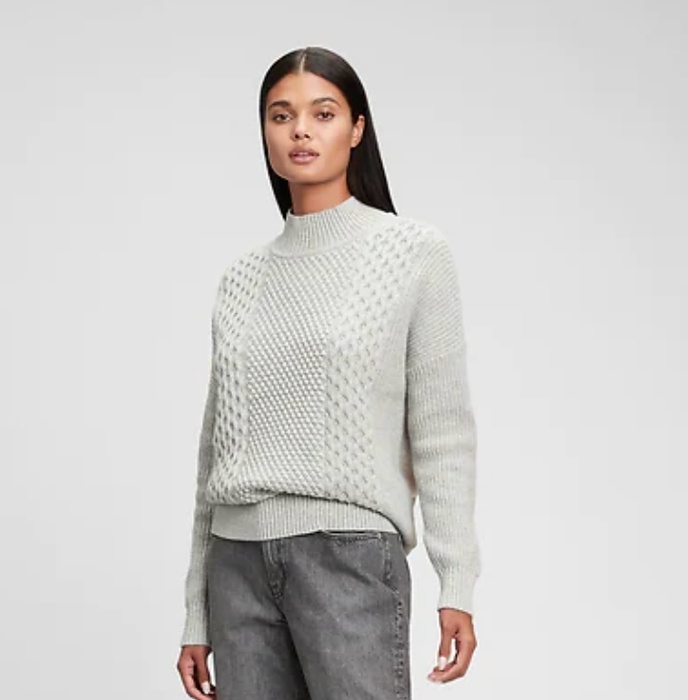 The model is seen wearing a grey sweater