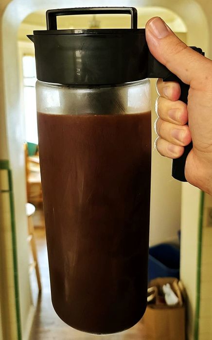 a photo from a reviewer showing a hand holding a carafe filled with cold brew coffee