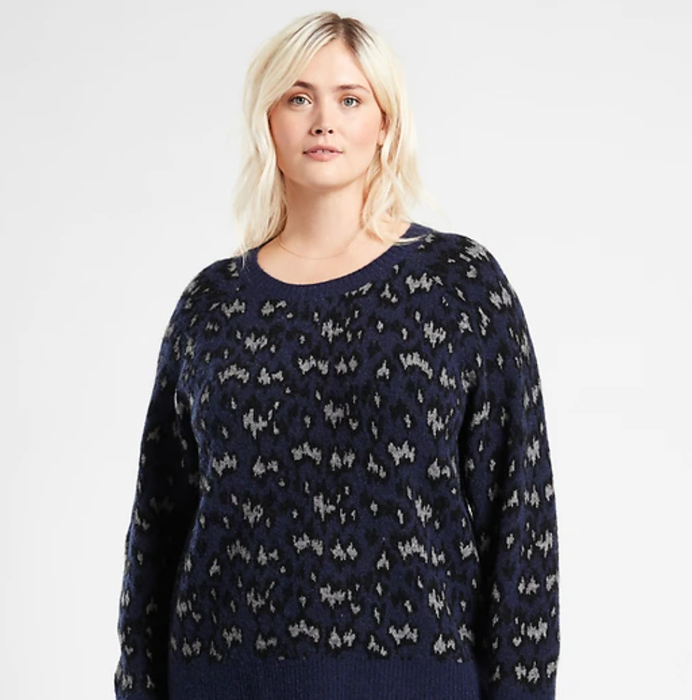 A model is wearing the textured sweater in blue and grey.