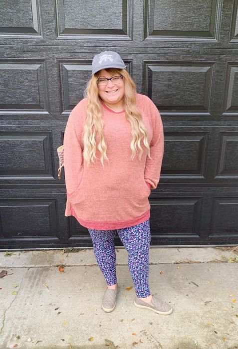 A reviewer is seen wearing the sweater in pink.