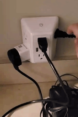 A reviewer demonstrating the charger's light being turned on and off while devices are plugged in