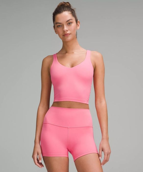 A model is seen showcasing a coordinated athletic outfit, consisting of a tank top and shorts. The fitted ensemble encourages activewear shopping.