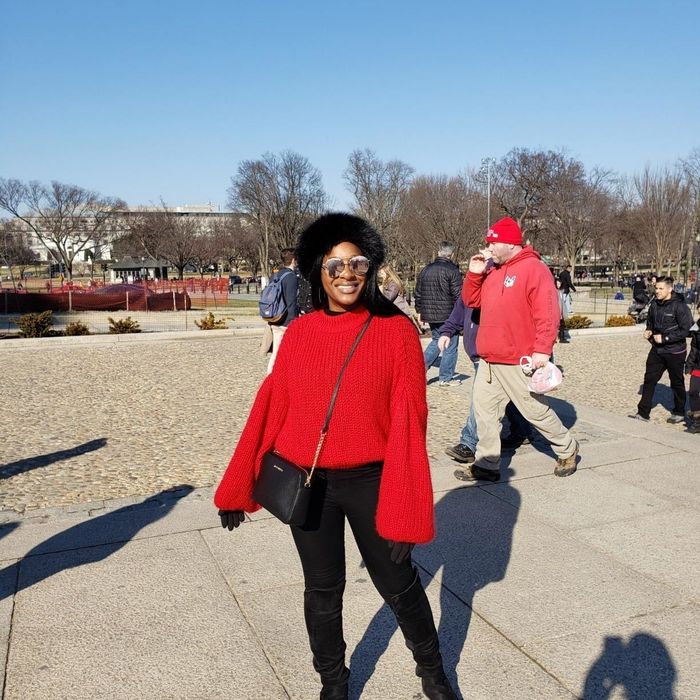A reviewer is seen wearing the sweater in bright red.
