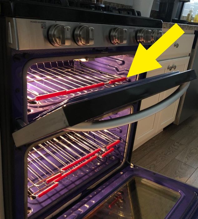 a photo of an open oven showcasing red guards installed on the racks