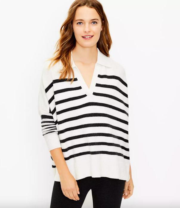 A model is wearing the white collared poncho with navy horizontal stripes.