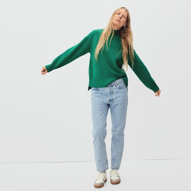 A model wearing a green turtleneck sweater.