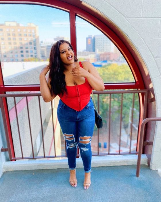 A reviewer showcasing the top in a vibrant red