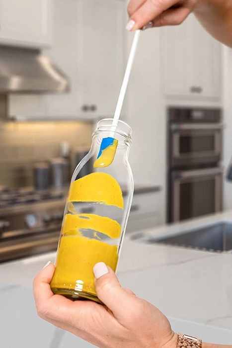 A model using a small spatula to extract mustard from a jar