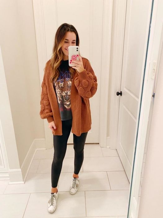 The reviewer is pictured wearing a sweater with brown balloon sleeves featuring a polka-dot texture