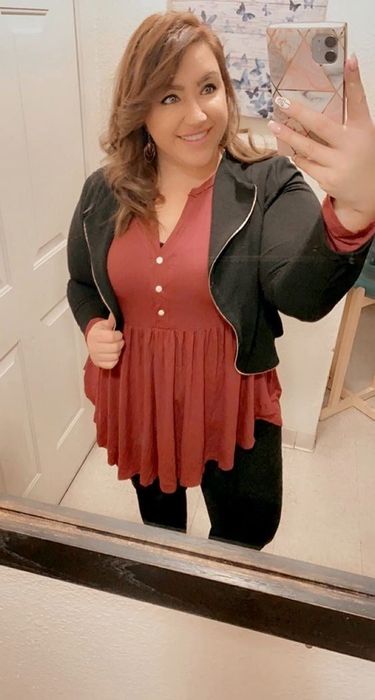 A reviewer wearing the top in a soft salmon shade