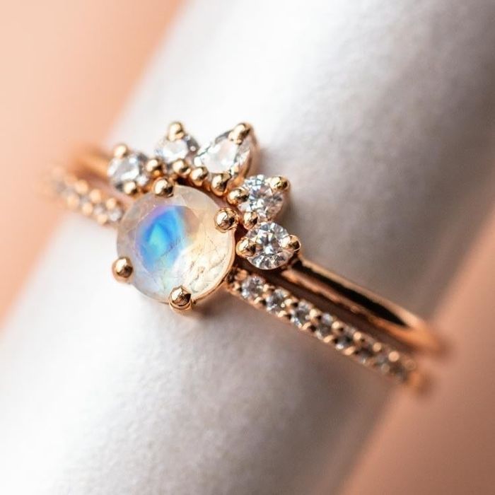 the ring showcasing a white stone outer layer with a captivating opal centerpiece