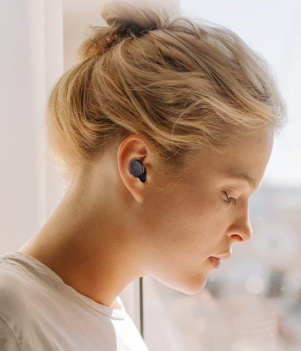 A model showcasing a stylish black earbud