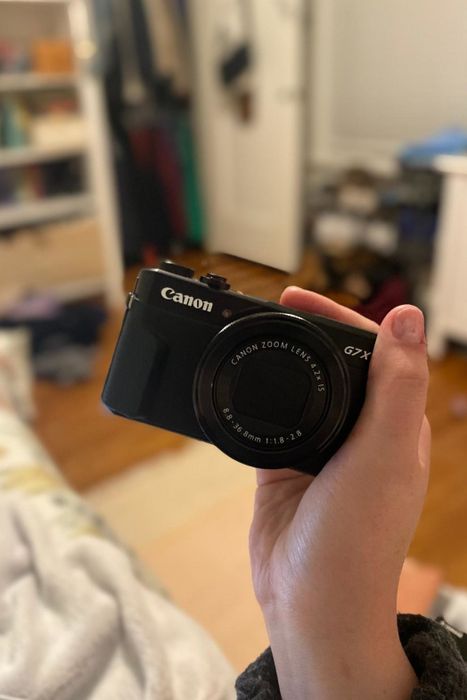 reviewer posing with the Canon PowerShot camera