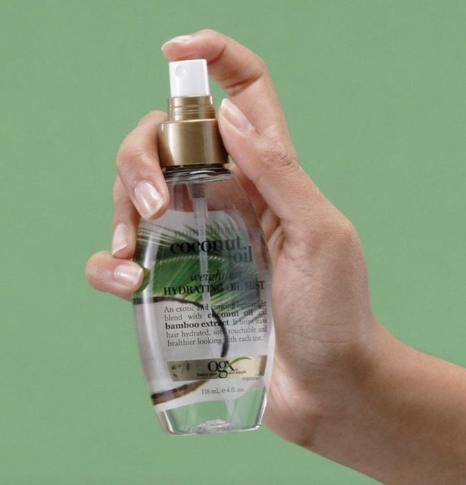 A person holding a bottle of hair mist