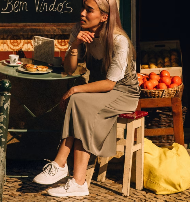 A model showcasing white sneakers paired with a slip dress