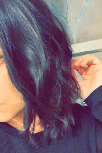 The reviewer's hair styled with loose waves after using the curling iron function of the versatile hair appliance.