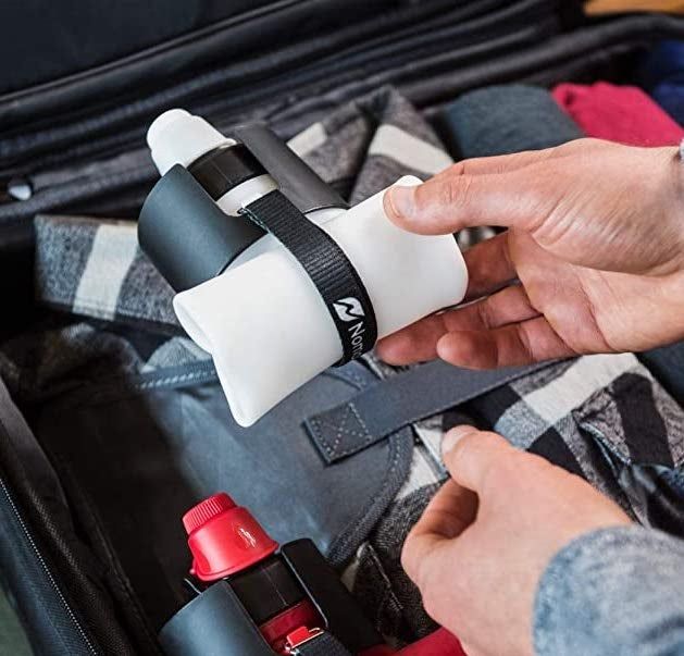 A pair of hands holding the compact, rolled-up white water bottle