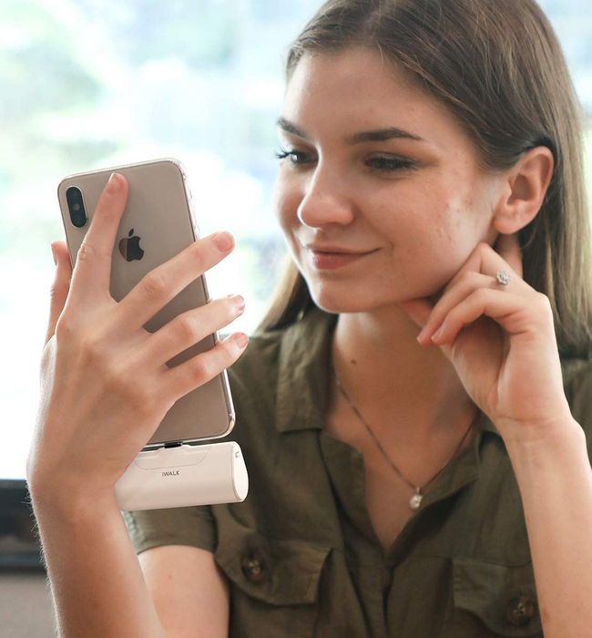 A model holding a phone connected to the sleek white charger