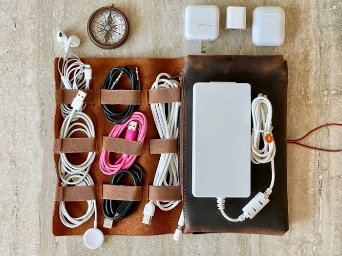 An overhead view of a charger organizer filled with various cords, neatly arranged and secured.