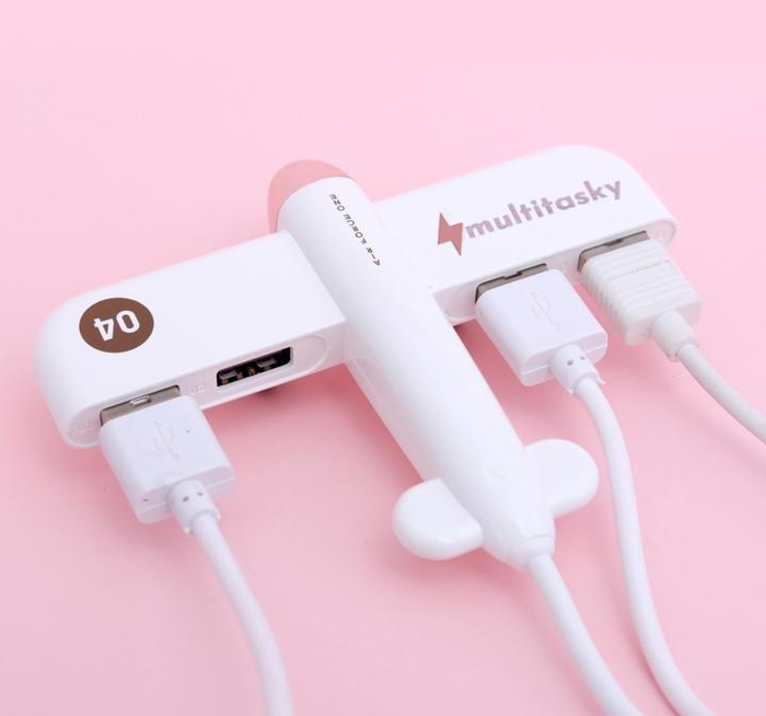 A sleek white USB hub featuring four ports designed to resemble an airplane