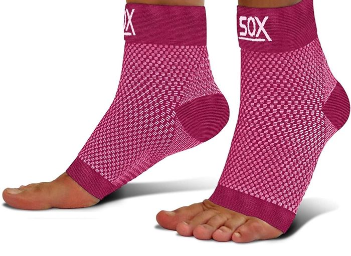 A model wearing pink compression socks that showcase their toes for extra comfort and style.