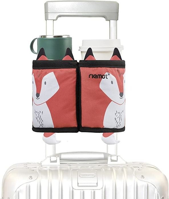 A stylish fox-patterned drink holder mounted on the handle of a rolling suitcase