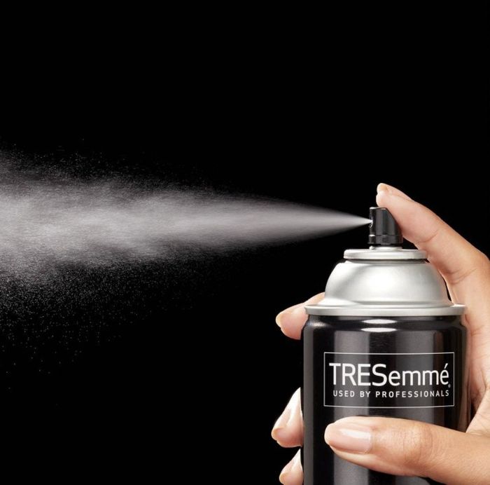 A person applying hairspray