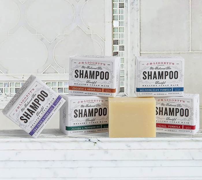 Five different shampoo bars displayed on a bathroom counter