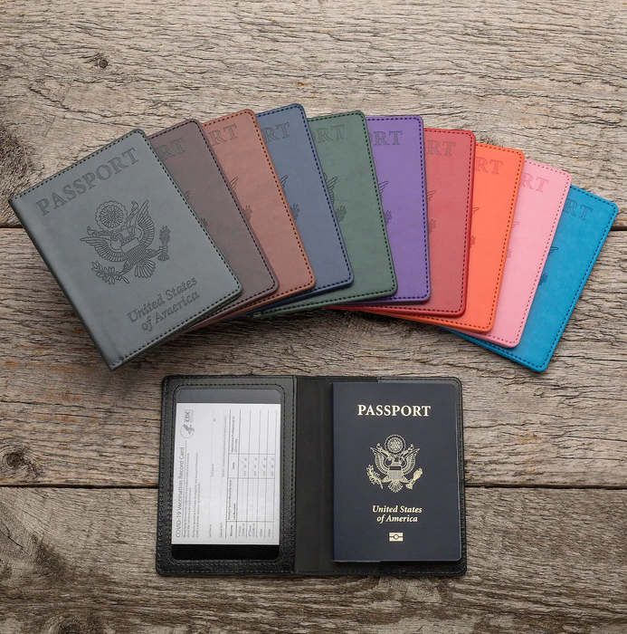 A black holder containing a vaccination card and passport, displayed alongside a variety of holders in different colors