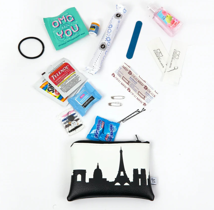 A monochrome storage pouch featuring the Paris skyline alongside an assortment of mini emergency essentials included in the kit