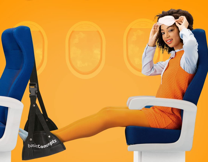 A model demonstrating the use of the foot hammock while seated in an airplane