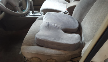 The cushion placed comfortably on a car seat, offering support for long drives.