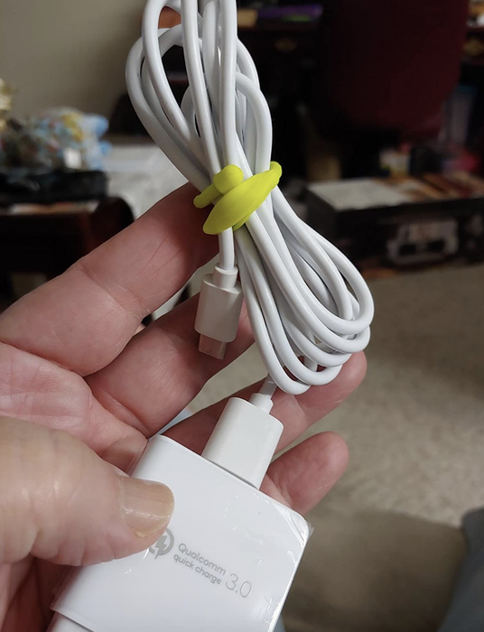 A reviewer's photo of a yellow twist tie securing a white cord.