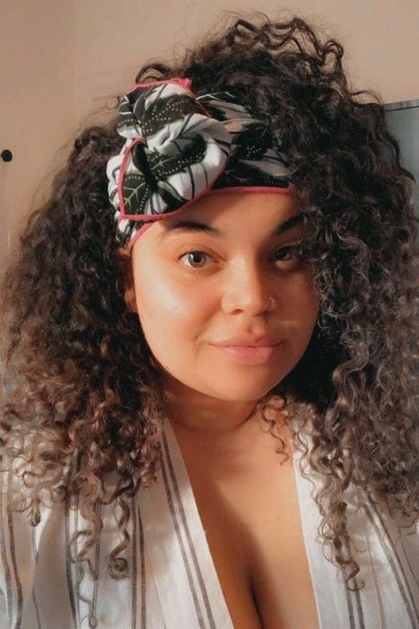The Mytour Shopping editor wearing a green, white, and pink floral wrap in her curly hair.