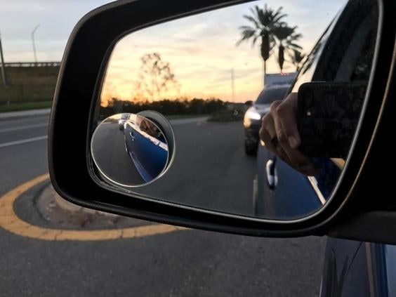 A reviewer's photo of the blind spot mirror attached to their side view mirror.