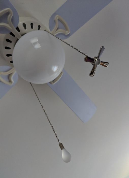 A reviewer's photo of a ceiling fan featuring two silver chains.