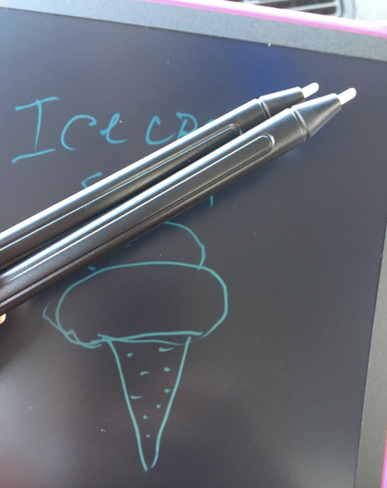 A reviewer captures an image of the tablet alongside its accompanying black pens.