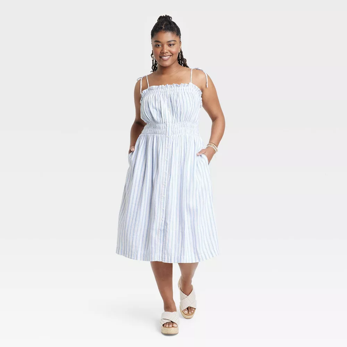 A model dressed in a blue and white striped dress