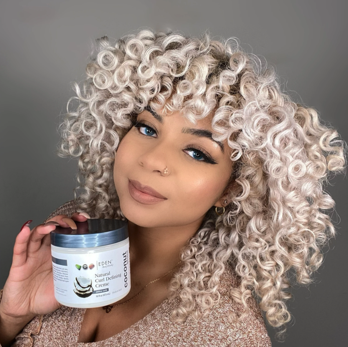 A model showcasing the jar of curl defining cream.